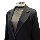 Detalle de chaqueta con solapa y top brillante del traje de fiesta